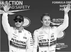  ?? — AFP photo ?? A file photo taken on Sept 26, 2015, shows Mercedes driver Nico Rosberg of Germany (right) waving after claiming pole position ahead of teammate Lewis Hamilton of Britain (left) following the qualifying session of the Formula One Japanese Grand Prix in...