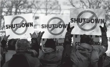  ?? Erin Schaff / New York Times ?? Air traffic controller­s union members protest the shutdown outside the Capitol in Washington. Consumer confidence in the economy is ebbing, surveys show.