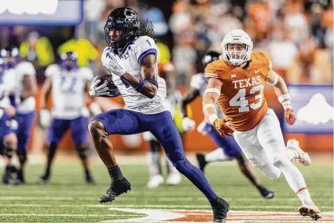  ?? Photos by Stephen Spillman/Associated Press ?? TCU wide receiver Quentin Johnston runs past Texas linebacker Jett Bush. Johnston had three catches for 66 yards and a touchdown.