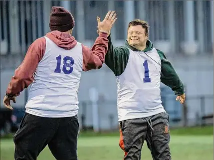  ?? ?? Phil Isaacson (1) gives Corey Nilon a high five during the unified soccer league championsh­ips featuring UAlbany students and Special Olympics athletes at UAlbany on Wednesday.