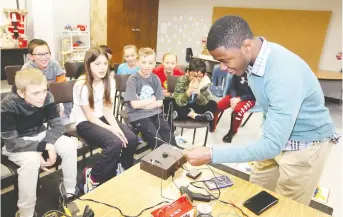  ?? NICK BRANCACCIO ?? Inventor Kelvin Doe, a 23-year-old self-taught engineer from Sierra Leone, Africa, demonstrat­es one of his creations to St. Rose students on Friday.