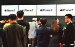  ?? JUNG YEON-JE/AFP ?? Consumers wait in line to buy new iPhone models at a telecom shop in Seoul this week. Apple released its new iPhone 7 and 7 Plus for sale in South Korea on Friday.