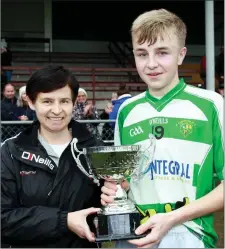  ??  ?? O Raghallaig­h’s captain Ryan Brodigan receives The Argus U-16 trophy from Margaret Comey.
