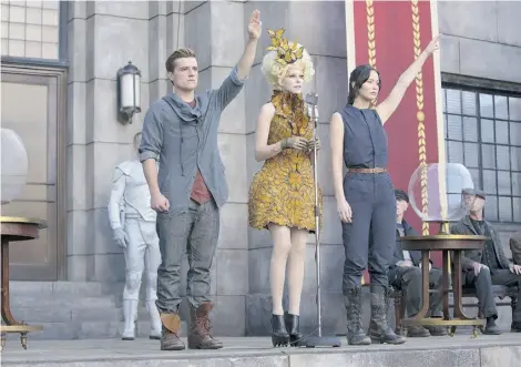  ?? MURRAY CLOSE/LIONSGATE FILMS ?? Josh Hutcherson, left, as Peeta Mellark, Elizabeth Banks as Effie Trinket and Jennifer Lawrence as Katniss Everdeen in the Hunger Games sequel, a film that’s expected to blow the doors off the box office.