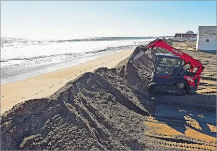  ?? SEAN D. ELLIOT/THE DAY ?? Jeremy Place of Morrone Excavation uses a compact track loader Tuesday to rebuild the sand dune at Jim’s Beach Trailer Park on Atlantic Avenue in Westerly. The nor’easter last weekend washed the sand of the dunes into the trailer park lot, and Place...