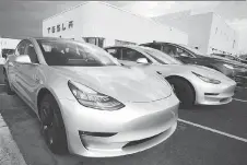  ?? DAVID ZALUBOWSKI/THE ASSOCIATED PRESS FILES ?? Model 3 sedans sit on display outside a Tesla showroom in Littleton, Colo., last month.