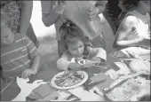  ??  ?? Alvina Sengar, 2, decorates a carousel horse craft.