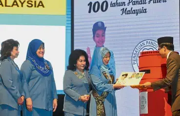  ??  ?? Special day: Tuanku Haminah launching the special stamp and the 100 Years Girl Guides First Day Cover in Kuala Lumpur as Rosmah (third from left) looks on.