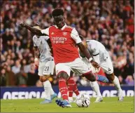  ?? Shaun Botterill / Getty Images ?? Arsenal’s Bukayo Saka scores his team’s third goal from the penalty spot against Liverpool on Sunday.