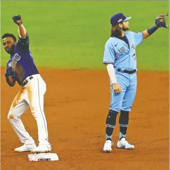  ?? MIKE EHRMANN/GETTY IMAGES ?? Tampa Bay's Randy Arozarena catches his balance after hitting a second inning double on Wednesday as Blue Jays shortstop Bo Bichette awaits a throw. The Rays ousted the Jays with an 8-2 win.