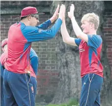  ?? ?? Matty Hayward, right, 15, is congratula­ted after taking a wicket