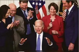  ?? Alex Wong / Getty Images ?? President Joe Biden gestures after he handed Sen. Amy Klobuchar, D-Minn., second from right, his signing pen as Sen. Maria Cantwell, D-Wash., left; Rep. Pete DeFazio, D-Ore., second from left; and Rep. John Garamendi, D-Calif., look on at the State Dining Room of the White House on Thursday. Biden signed the Ocean Shipping Reform Act of 2022 into law.