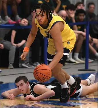  ?? CHRIS CHRISTO — BOSTON HERALD ?? New Mission’s Lawrence JaJa Davis takes the ball from a Pioneer Valley player Wednesday. New Mission earned a 60-47 state semifinal victory.