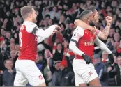  ??  ?? Arsenal’s Alexandre Lacazette (C) celebrates after scoring his team’s first goal with teammates during the EPL match against Liverpool