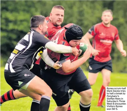  ??  ?? Bynea scrum-half Mark Davies tries to halt a break by Penybanc’s Steffan Rees in Saturday’s Three West B encounter. Visitors Bynea won 58-5.