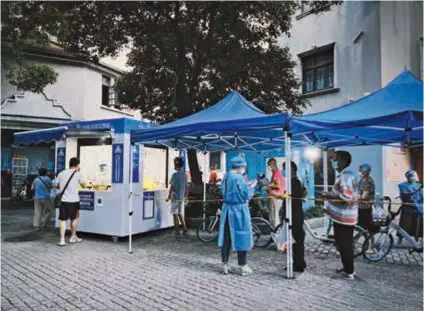  ?? — IC ?? People queue up for nucleic acid test in Shanghai. Continuous polymerase chain reaction screening is being conducted across the city to contain the recent COVID-19 resurgence.