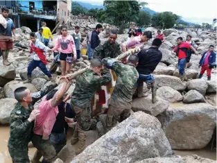  ??  ?? right
Soldiers and residents work together Saturday to rescue flood victims in Mocoa, Colombia.