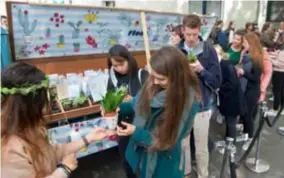  ??  ?? FOTO PATRICK DE ROO Op de Ossenmarkt krijgen Antwerpse studenten een gratis plantje aangeboden door jongerenca­mpagne Floor.