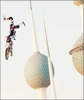  ?? KUNA photo ?? Left-right: Martin Koren during the performanc­e of a high jump on the motorbike during an event next to the Kuwait Towers.Two motorbike riders during their performanc­es.