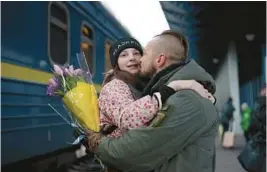  ?? ROMAN HRYTSYNA/AP ?? Ukrainian soldier Vasyl Khomko kisses his daughter Yana on Saturday at a train station in Kyiv. Yana and her mother have been living in Slovakia while the war rages on.