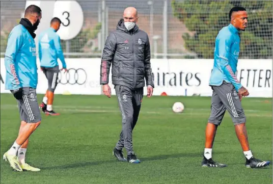  ??  ?? Zidane, junto a Benzema y Militao, durante el entrenamie­nto de ayer en la Ciudad Deportiva de Valdebebas.