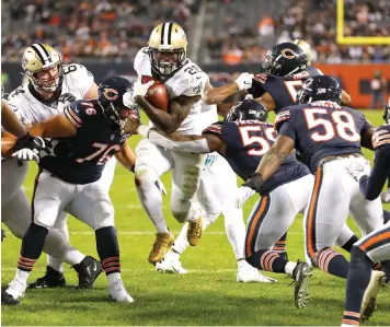 ?? Charles Rex Arbogast/Associated Press ?? ■ New Orleans Saints running back Latavius Murray (28) runs in for a touchdown between Chicago Bears defensive tackle Abdullah Anderson (76) and inside linebacker Danny Trevathan (59) during on Sunday in Chicago.