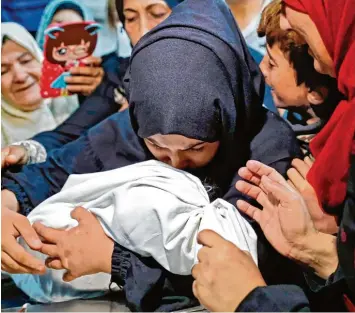  ?? Foto: Thomas Coex, afp ?? Eine palästinen­sische Mutter trägt ihr acht Monate altes Baby zu Grabe. Es war gestorben, nachdem es Tränengas im Umfeld der Proteste in Gaza eingeatmet hatte.