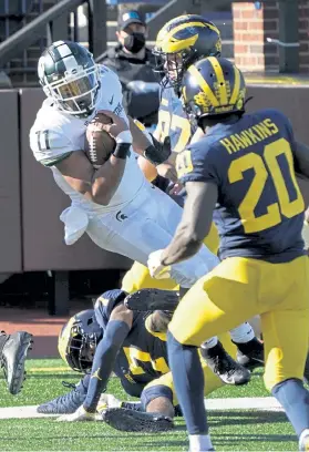  ?? Carlos Osorio, The Associated Press ?? Michigan State running back Connor Heyward flips over Michigan defensive back Makari Paige for a touchdown during the second half on Saturday in Ann Arbor, Mich.