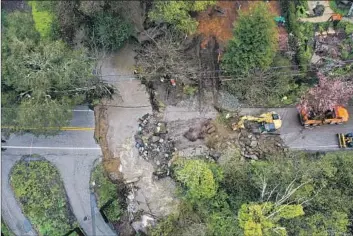  ?? Tayfun Coskun Anadolu Agency/Getty Images ?? A ROAD in Santa Cruz washed away Friday during the latest atmospheri­c river to hit California. Gov. Gavin Newsom proclaimed a state of emergency in 34 counties, activating the California National Guard to assist.