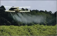  ?? DAVE MARTIN, FILE — THE ASSOCIATED PRESS ?? In this photo taken Aug. 4, 2009 file photo, a crop duster sprays a field of crops.