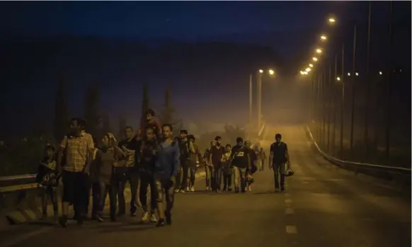  ?? SANTI PALACIOS/THE ASSOCIATED PRESS ?? Syrian refugees escape war and poverty Tuesday along roads near the town of Idomeni, Greece, preparing to cross into Macedonia, which has lifted a three-day blockade of its border.