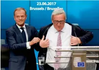  ?? AFP ?? European Council President Donald Tusk helps EU Commission President Jean Claude Juncker with his jacket before they address a joint Press conference in Brussels on Friday. —