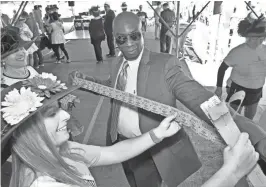  ?? PAT A. ROBINSON / FOR THE JOURNAL SENTINEL ?? Above: Tony Meyers buys an arm’s length worth of raffle tickets from Hallie Gergerich as Michelle Zimmermann waits during the 10th anniversar­y of the Derby Day Party Saturday at Maxie's restaurant. The celebratio­n includes a fundraiser for the Hunger...