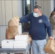  ?? H John Voorhees III / Hearst Connecticu­t Media ?? Area business owner Leo Spinelli Jr. delivers a donation of bagels and donuts to Danbury Hospital, accompanie­d by his son, Leo Spinelli III, on Thursday.