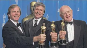  ?? RICHARD DREW/AP ?? Branko Lustig (right), Douglas Wick (left) and David Franzoni hold their Oscars backstage after “Gladiator” was honored as best picture on March 25, 2001.