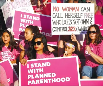  ??  ?? Supporters and patients of Planned Parenthood take part in a ‘Pink the Night Out’ rally at City Hall, which is part of a nationwide series of actions in support of the organisati­on and in opposition to Trump’s health care proposal, in Los Angeles,...