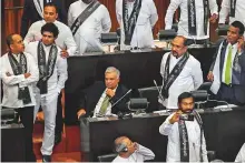  ?? AFP ?? Sri Lanka’s ousted prime minister Ranil Wickremesi­nghe (C) attends the parliament session in Colombo yesterday.