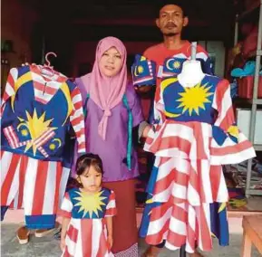  ?? PIC BY OMAR AHMAD ?? Rozita A. Manap (left) with her husband and daughter at her shop in Kampung Gebut, Kota Tinggi, yesterday.