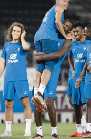  ?? (AFP) ?? France’s forward Marcus Thuram (C-R) jokes with France’s forward Kylian Mbappe (C-L) during a training session at the Jassim Bin Hamad Stadium in Doha on on Monday, on the eve of their FIFA World Cup Qatar 2022 match against Australia.