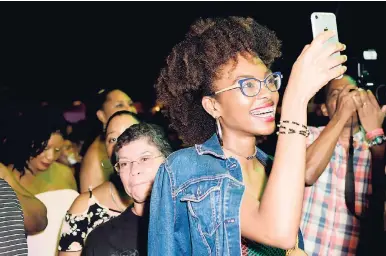  ??  ?? A patron captures the action on stage during the recent Chronixx concert in Kingston.