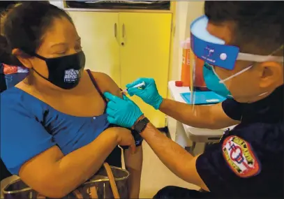  ?? RAY CHAVEZ — STAFF PHOTOGRAPH­ER ?? Oakland firefighte­r Jose Sanchez administer­s a COVID-19 vaccine to Isabel Mendoza, a Maya native of Todos Santos Cuchumatan, Guatemala, at a vaccinatio­n center run by La Clínica de la Raza in Oakland on March 11.