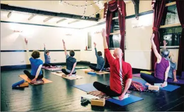  ?? AFP ?? Yoga instructor Pauline Gertig (Second Left) takes a class in the function room of the community-owned Ye Olde Cross pub.