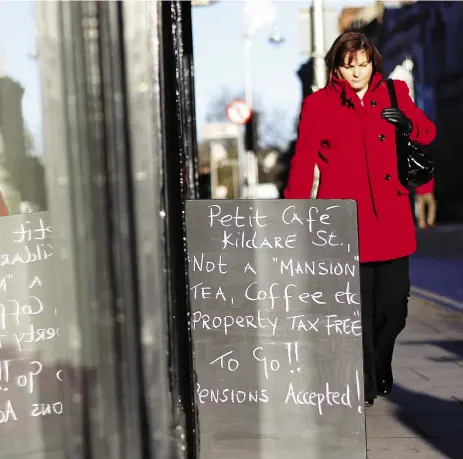  ?? Peter MUHLY / AFP / GETTY IMAGES ?? A sign outside a café in Dublin makes humorous reference to last year’s budget. With new figures showing
that the economy is contractin­g, Dublin’s boom is one of the few bright spots for Ireland.