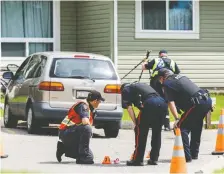  ?? AZIN GHAFFARI ?? Calgary police officers look at a small pink shoe left at the scene of a hit and run involving a 17-month-old girl who was transferre­d to Alberta Children’s Hospital in serious conditions on Monday.