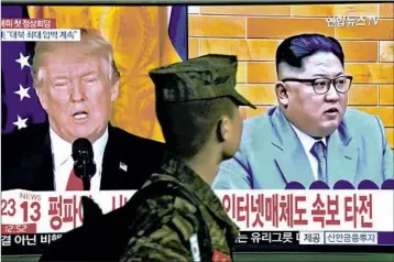  ?? JUNG YEON-JE/GETTY-AFP ?? A South Korean soldier walks Friday in Seoul past a television screen showing President Donald Trump and Kim Jong Un.