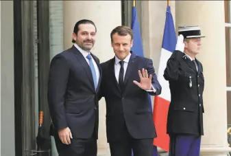  ?? Christophe Ena / Associated Press ?? Lebanese Prime Minister Saad Hariri (left) greets French President Emmanuel Macron in Paris. Hariri had been in Saudi Arabia since he suddenly announced his resignatio­n Nov. 4.