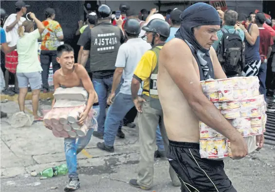 ??  ?? Los saqueos. Decenas de venezolano­s arrasan con la mercadería que pueden, de los negocios, en medio de una crisis generaliza­da. Reuters