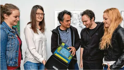  ?? Foto: Peter Fastl ?? Dieser „Defi“im Gebäude für Kunst und Musik an der Uni kam zum Einsatz. Dozent Christian Samajdar (Mitte) traf sich zum Bildtermin mit den Studenten Sophia, Katharina, Andreas und Corinna (von links) zu einer Nachbespre­chung. Sie waren an der Rettung...