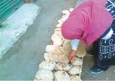  ?? Supplied picture ?? A woman collects subsidised bread. The value of subsidised food for ration card holders was doubled last month..