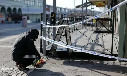  ?? Photograph: Adam Ihse/EPA ?? A man laying flowers at the scene of a fatal shooting in Gothenburg, Sweden, in March 2015.
